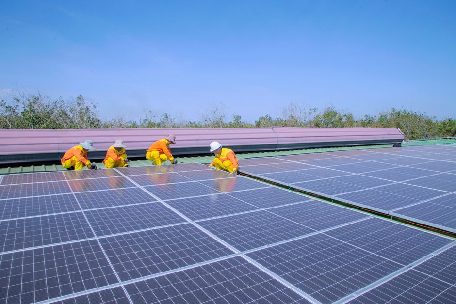 Workers installing solar panels on a sunny day, promoting renewable energy and sustainability.