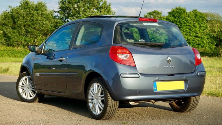 A shiny Renault Clio hatchback parked outdoors in a sunny UK location.