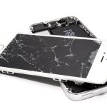 Close-up of a broken smartphone with a severely cracked screen.
